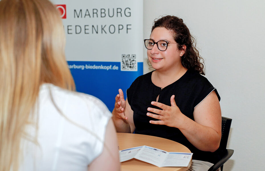 Studentin, die einer Kollegin etwas erkärt.
